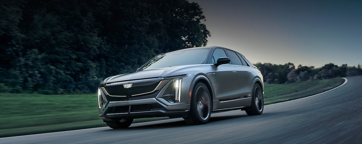 Three-quarter of a Magnus Metal Cadillac LYRIQ Driving At Dusk