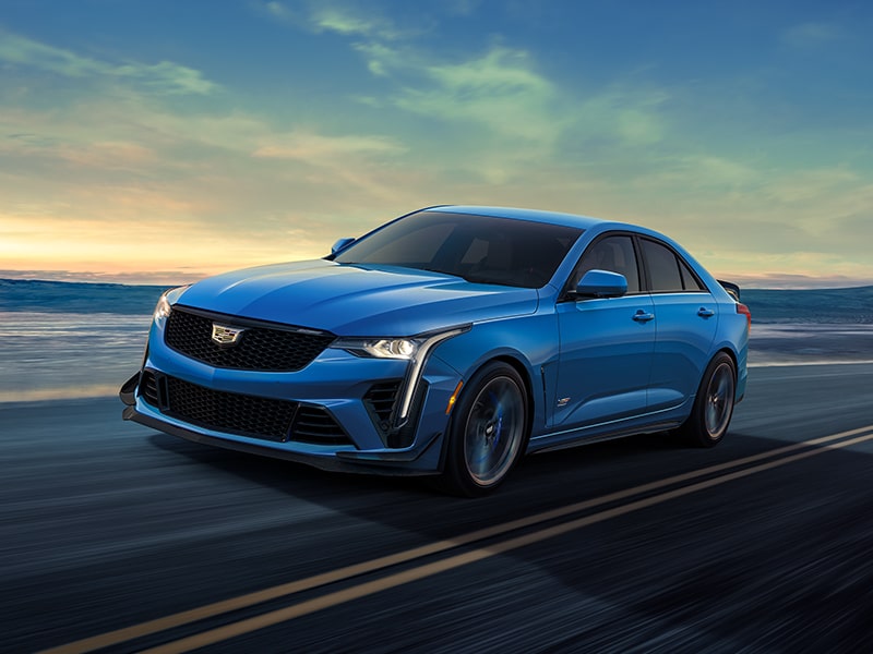 Three-quarters Front View of a Blue CT4-V Driving Down the Road