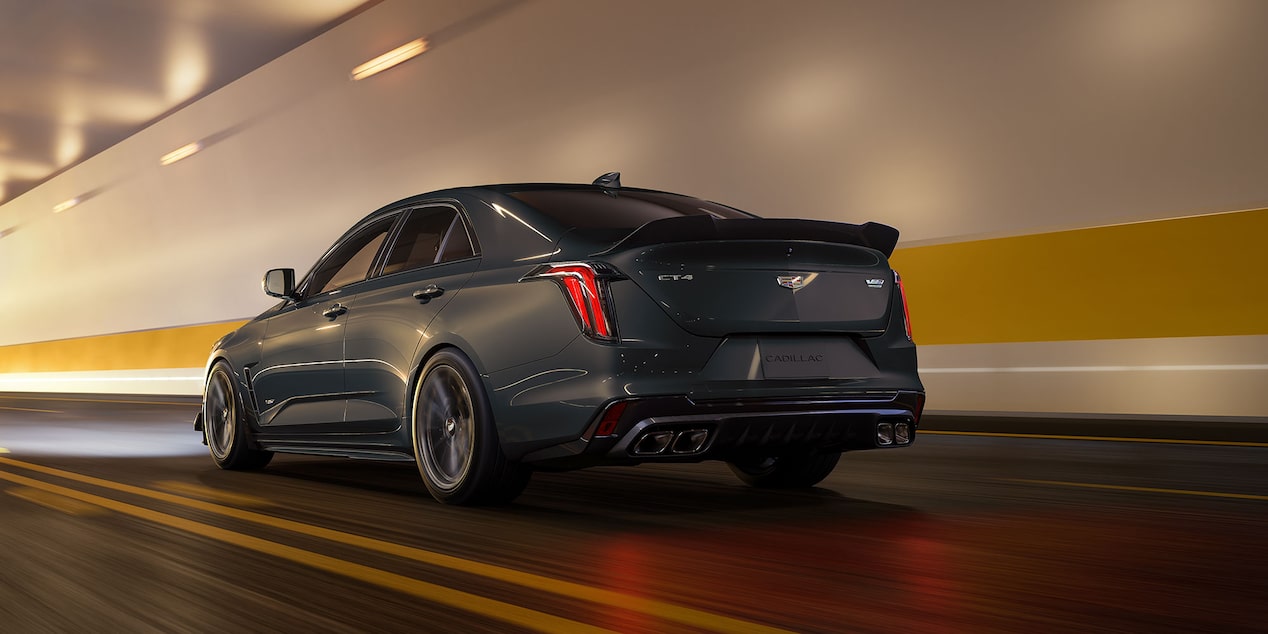 A Dark Gray Cadillac CT4-V Blackwing Sedan Parked on a Yellow-Striped Concrete Floor in a Dimly Lit Garage