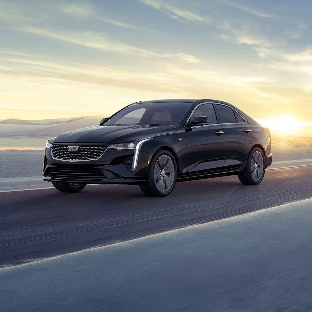 Three Quarters View of a 2025 CT4 Driving Through The Desert During a Sunrise