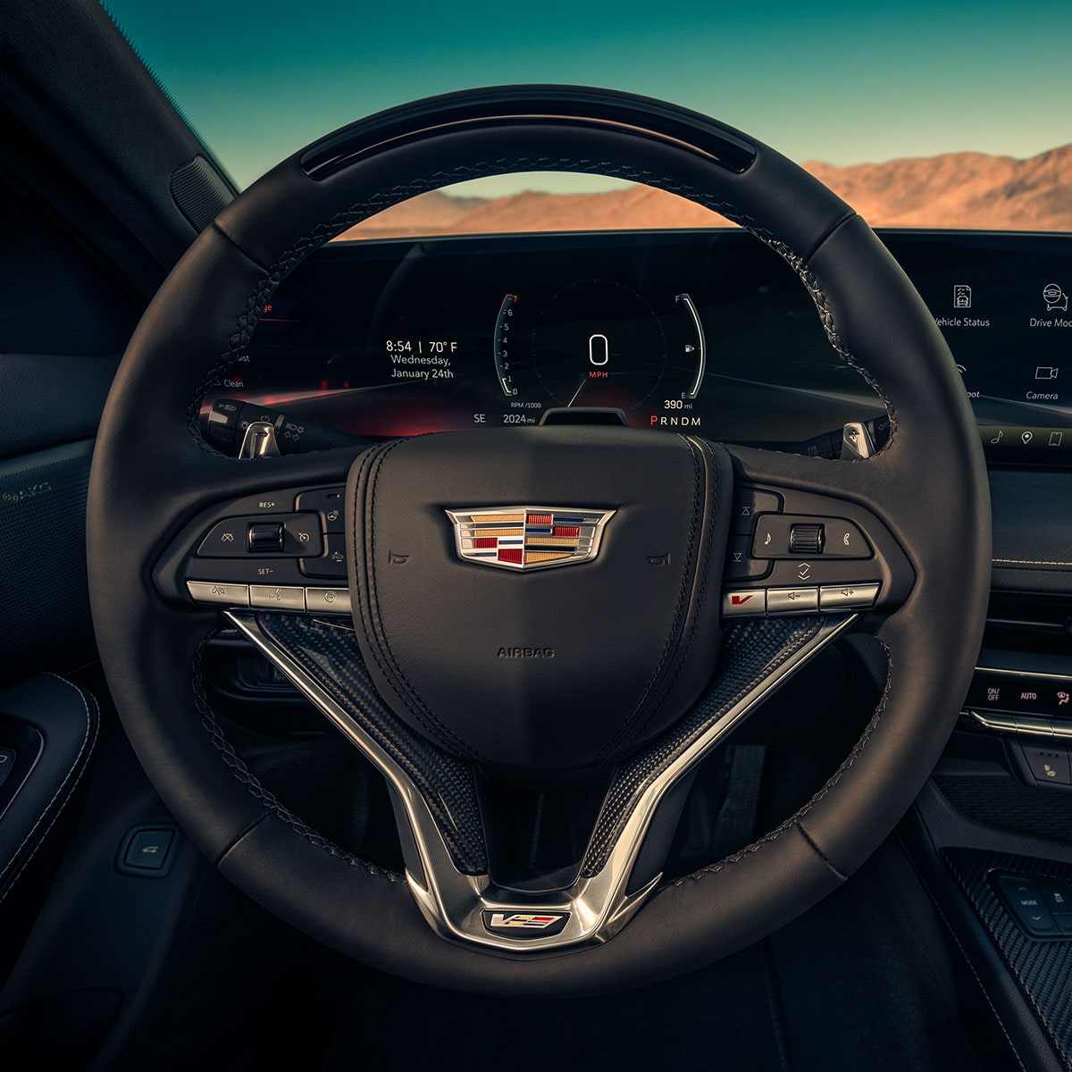Close-up Front Driver's Seat View of the Black Steering Wheel in a 2025 Cadillac CT5-V in Front of a Desert