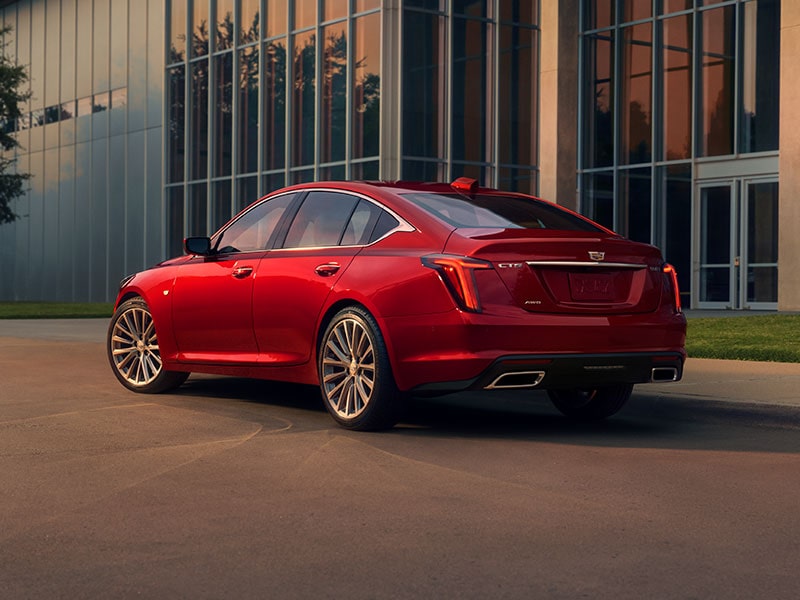 Rear View of the 2024 Cadillac CT5 in Radiant Red Tintcoat Parked Near an Industrial Building