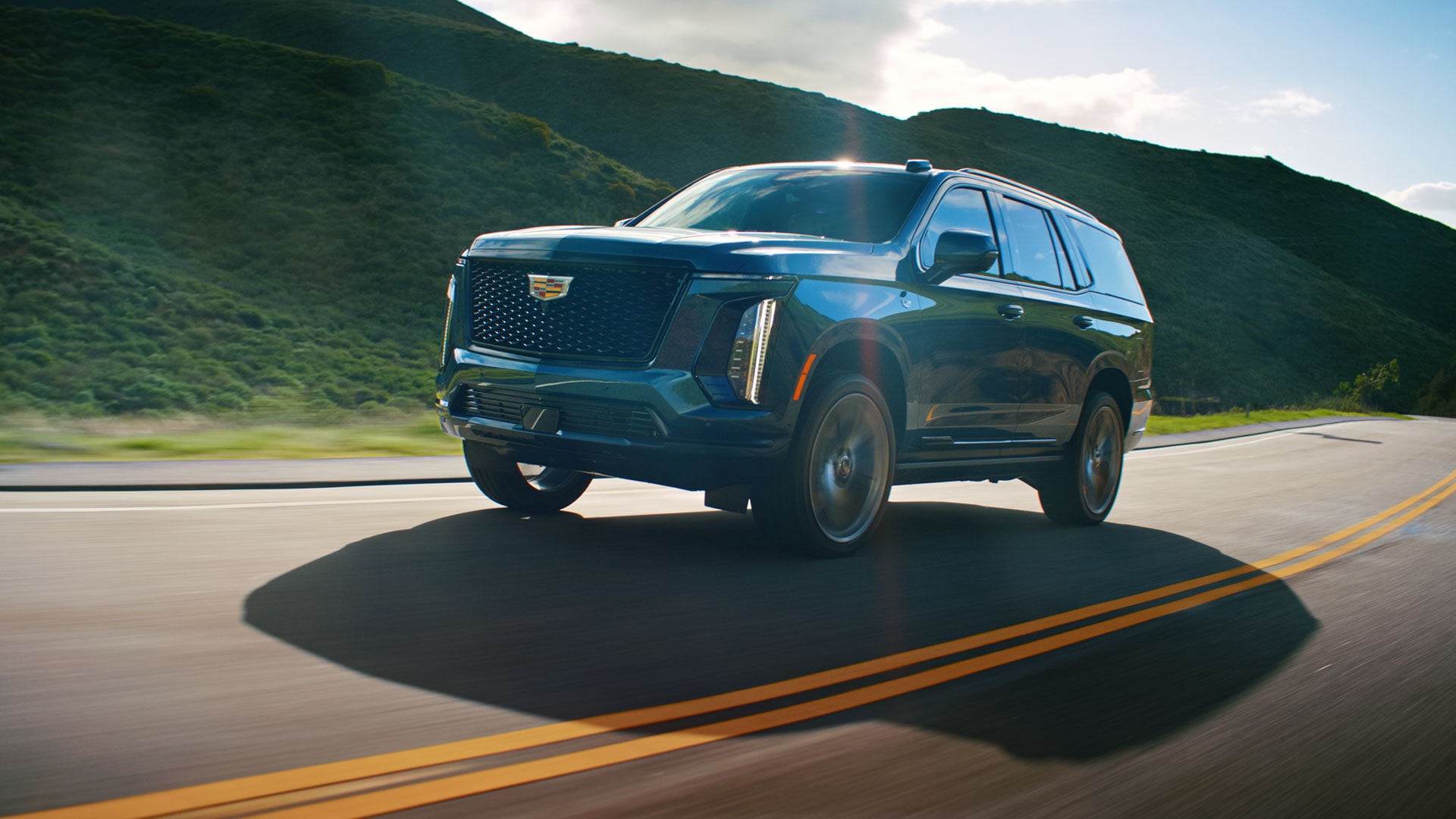 A Blue 2026 Cadillac Escalade Driving Through the Mountains