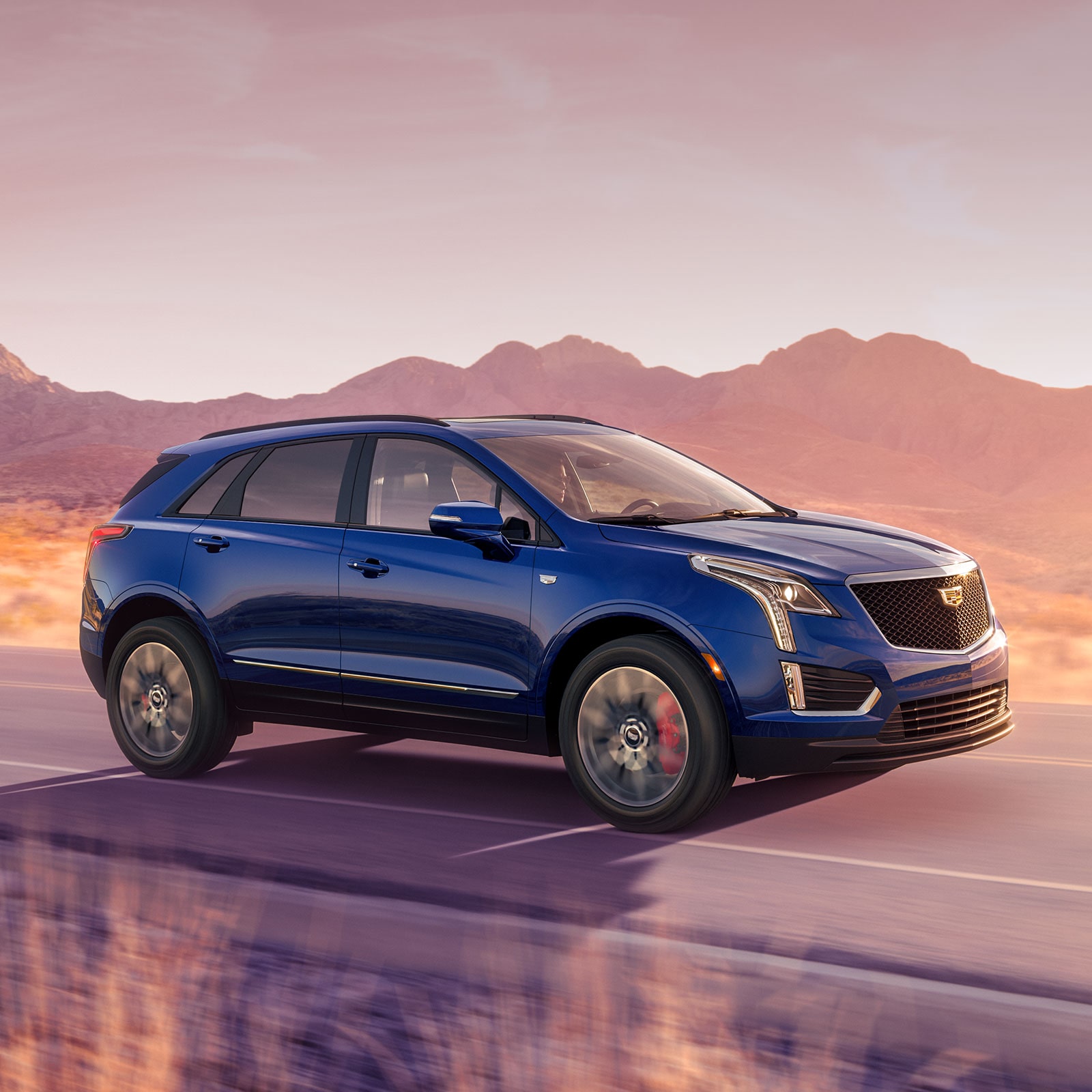 The 2026 Cadillac XT5 Driving Through a Western Landscape During Golden Hour