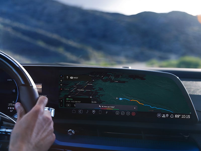 Close-up of Someone Driving the 2027 OPTIQ-V and Utilizing the Navigation on the Display Screen