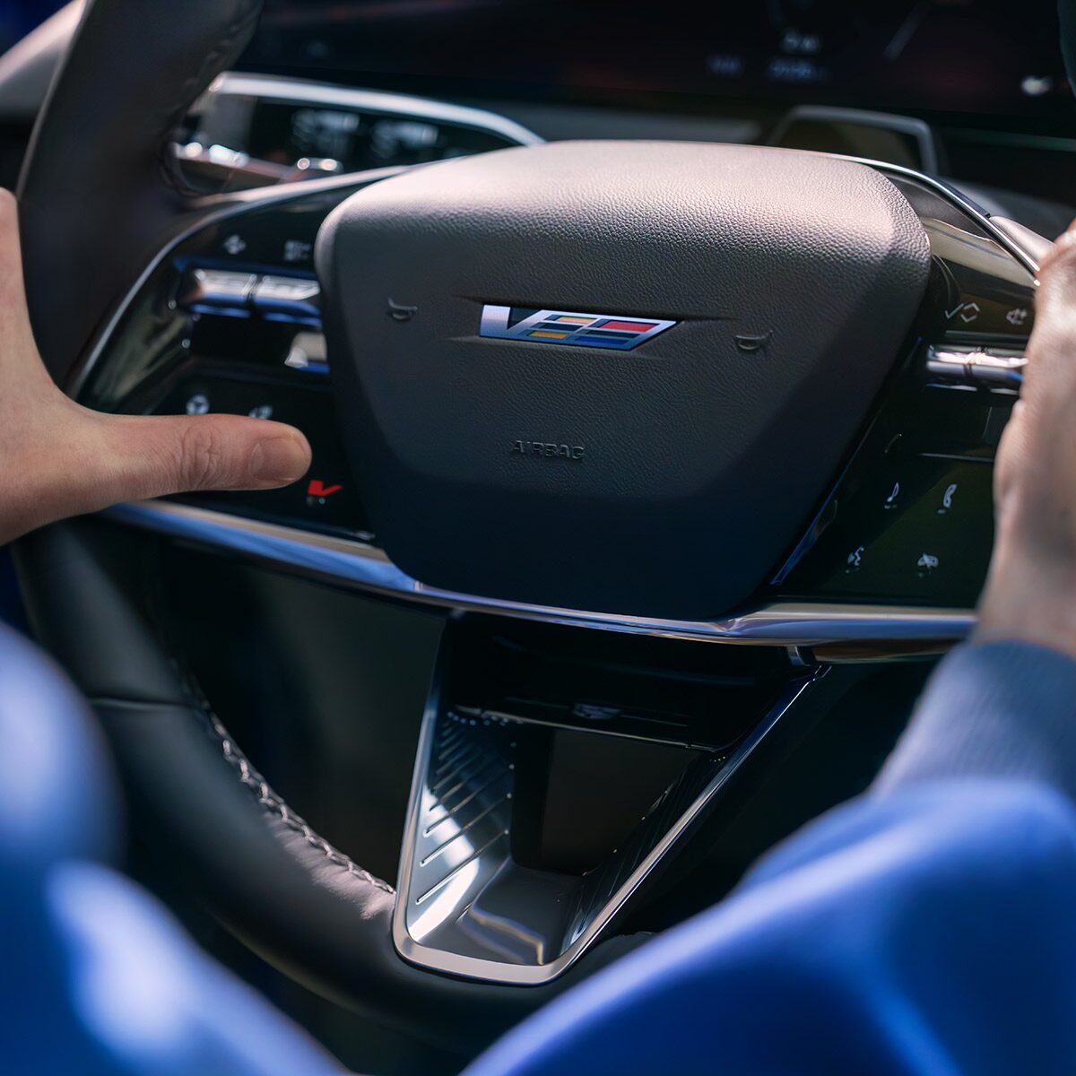 Close-up of Someone Pressing the V Button on a Cadillac OPTIQ-V Steering Wheel