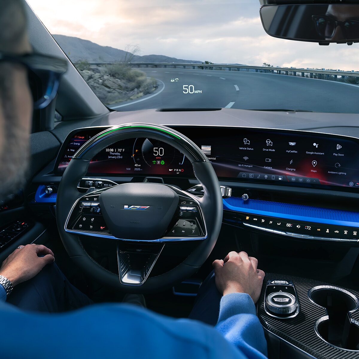 Driver Seat View of a Man Driving the 2027 OPTIQ-V Down a Road While Using the Hands-free Super Cruise Feature