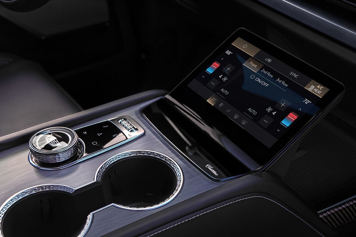 Close-up of the 2027 Cadillac VISTIQ Middle Console Including the Cup Holders, Gear Knob and Climate Control Screen