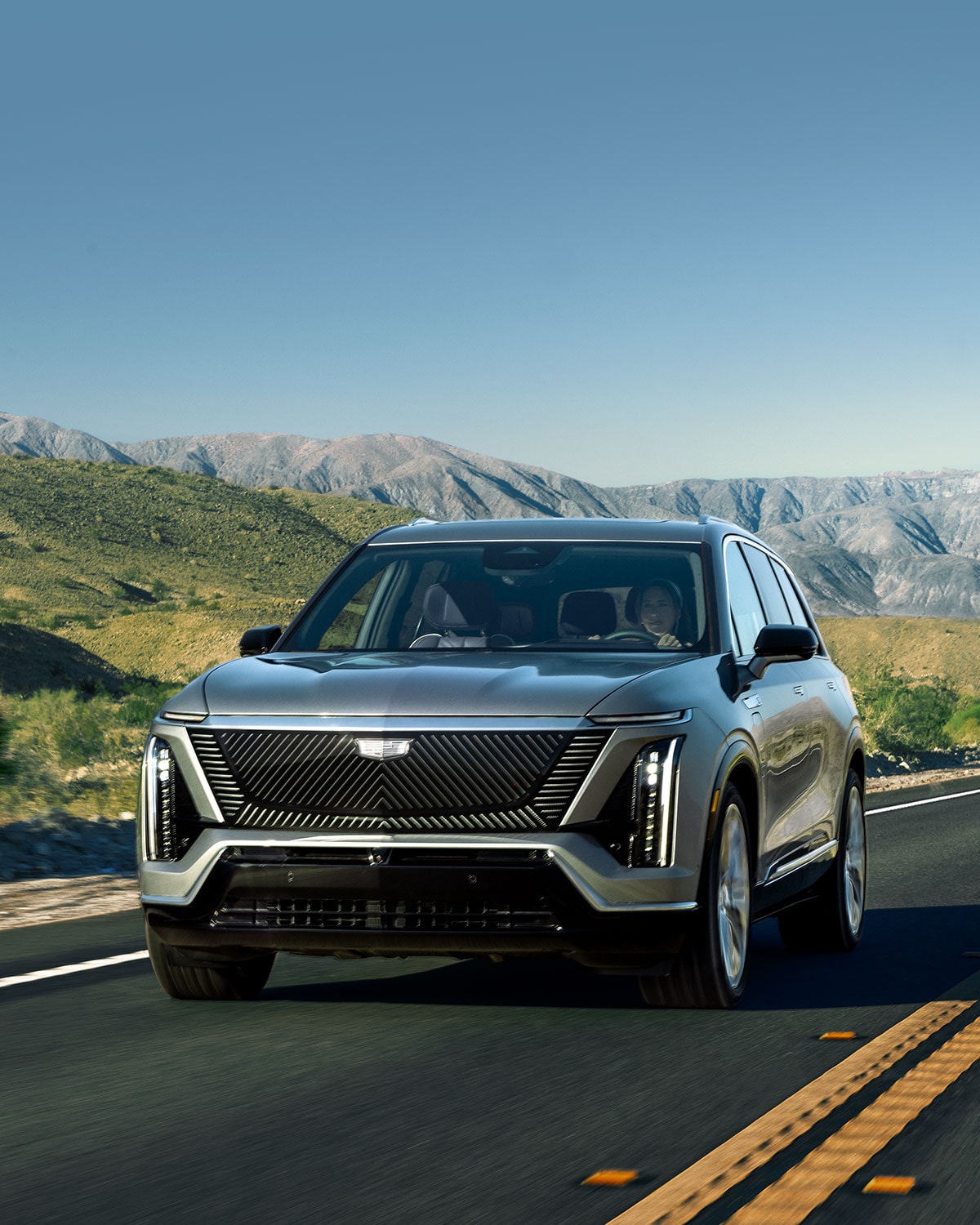 The 2027 Cadillac VISTIQ 3-row Electric SUV Driving Down a Road in the Mountains