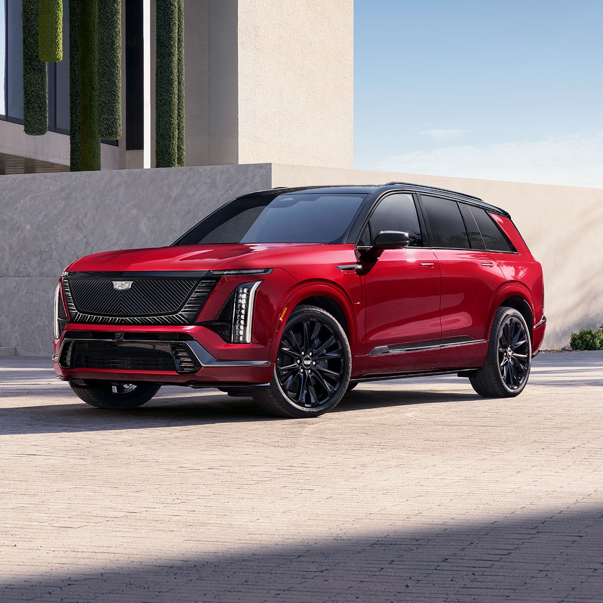 Three-quarters View of a 2027 VISTIQ 3-row Electric SUV Parked near a Concrete Wall