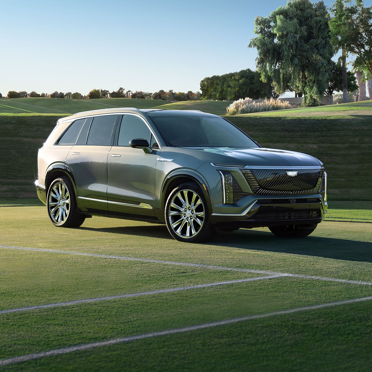 Three-quarter View of a 2027 Cadillac VISTIQ Parked on a Grassy Tennis Court