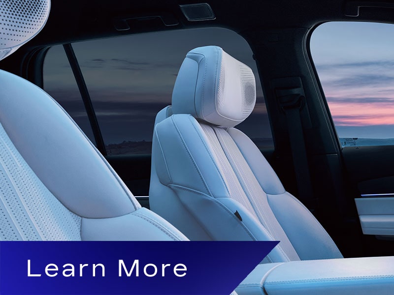 Passenger Seat View of the Driver Seat and Front Row Interior Inside the Cadillac VISTIQ Outlooking a Sunset