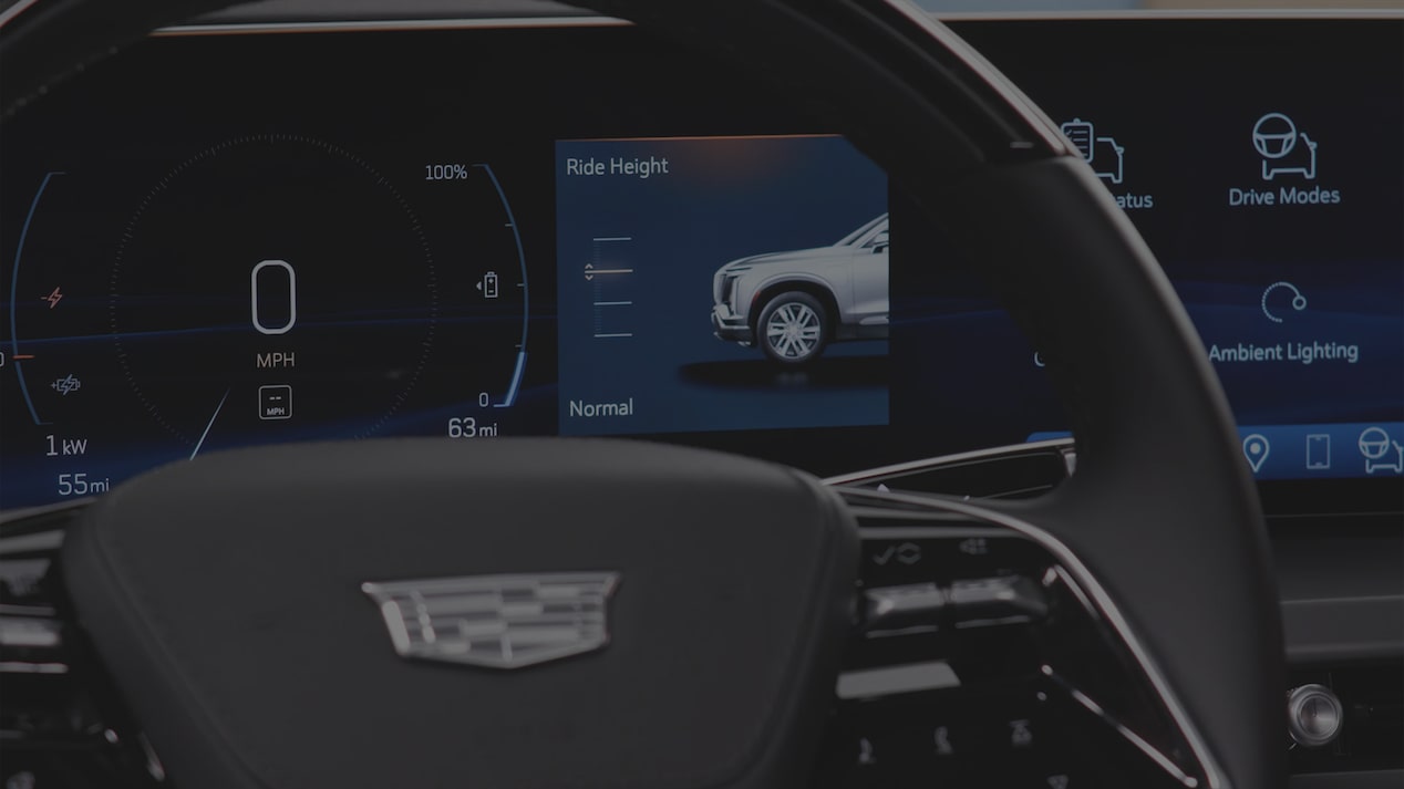 Close-up of a Cadillac VISTIQ Steering Wheel and Infotainment Screen Displaying Air Ride Adaptive Suspension Feature