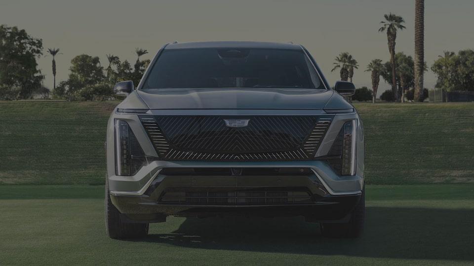 Front View of a 2027 VISTIQ 3-row Electric SUV Parked in a Grassy Tennis Court