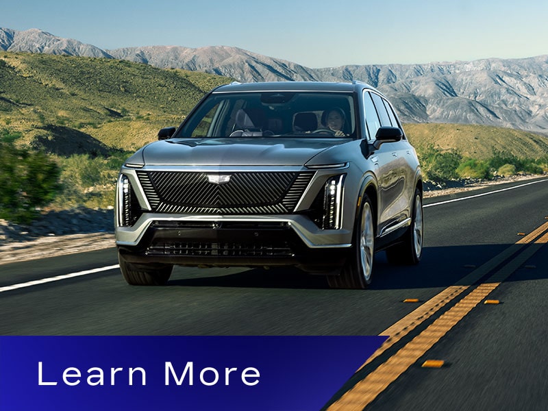 The Cadillac VISTIQ 3-row Electric SUV Driving Down a Road in the Mountains