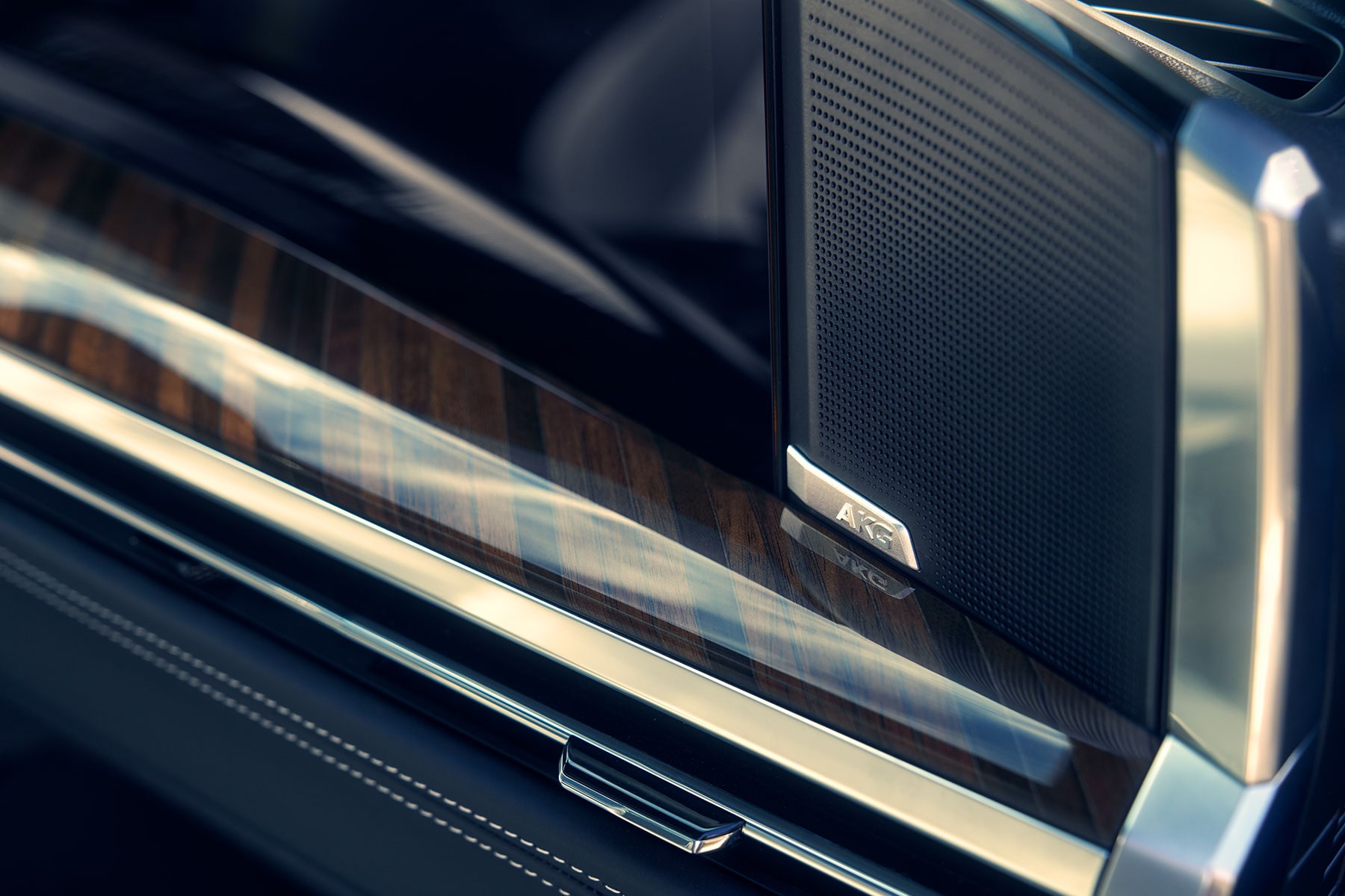 A Close-Up of an AKG Premium Audio Speaker Integrated Into the 2027 Escalade Door Panel With Wood Trim Accents