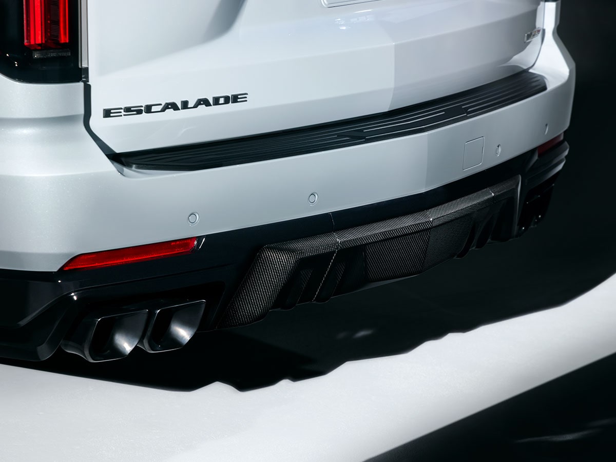Close-up of the Rear of a White Cadillac Escalade-V Collector Series Featuring Escalade Badging, a Carbon Fiber Rear Diffuser, and Quad Exhaust Outlets