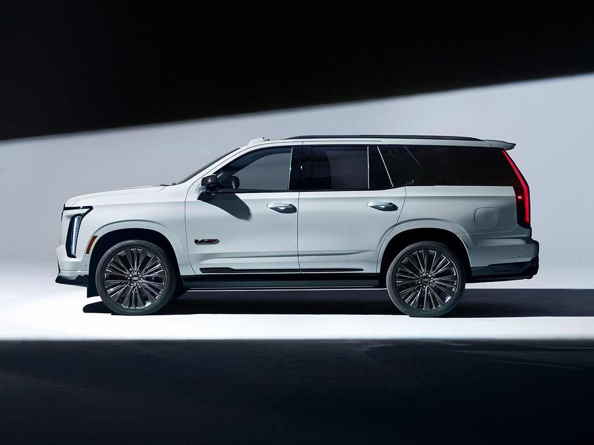 Profile View of Light Shining on a White Cadillac Escalade-V Collector Series Parked in a White Showroom