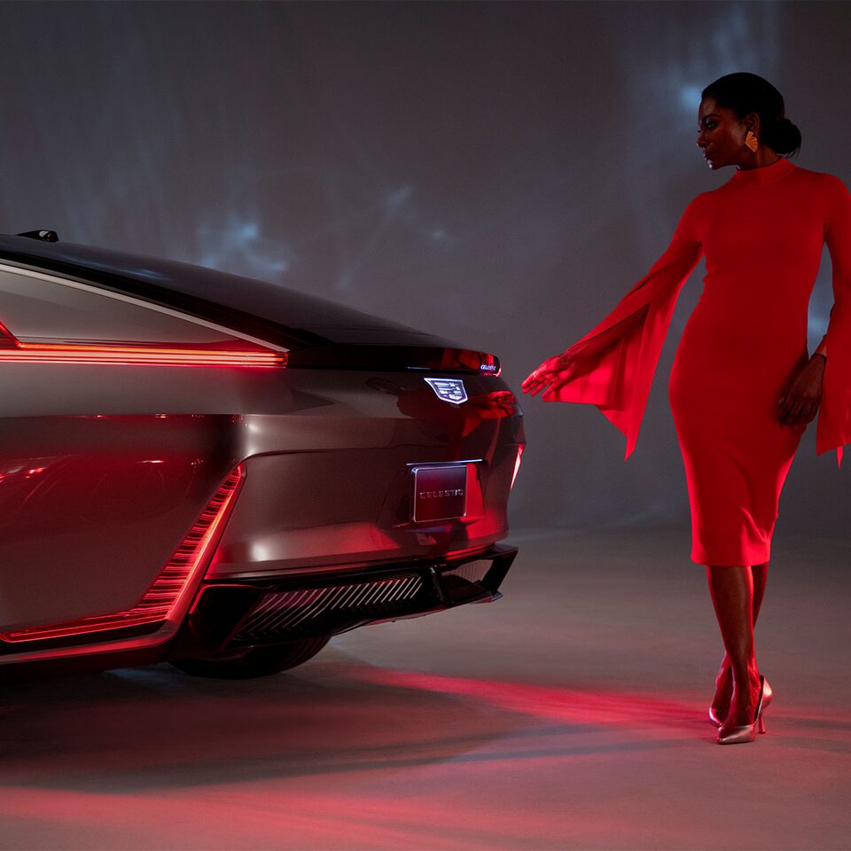 Woman Standing by Rear End of the Cadillac CELESTIQ with Tail Lights Illuminated