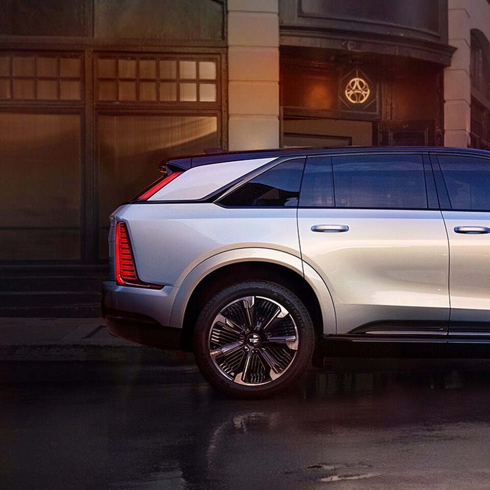 Side Profile of the 2025 Cadillac ESCALADE IQ Parked in Front of Buildings