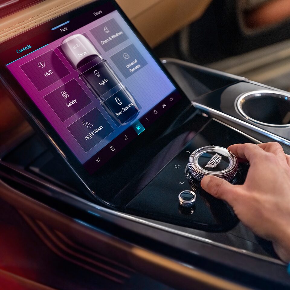 Side View of the Control Center with the Driver Adjusting the Knob Inside The 2025 Cadillac ESCALADE IQ