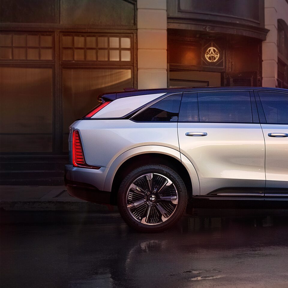 Side Profile of the 2025 Cadillac ESCALADE IQ Parked in Front of Buildings