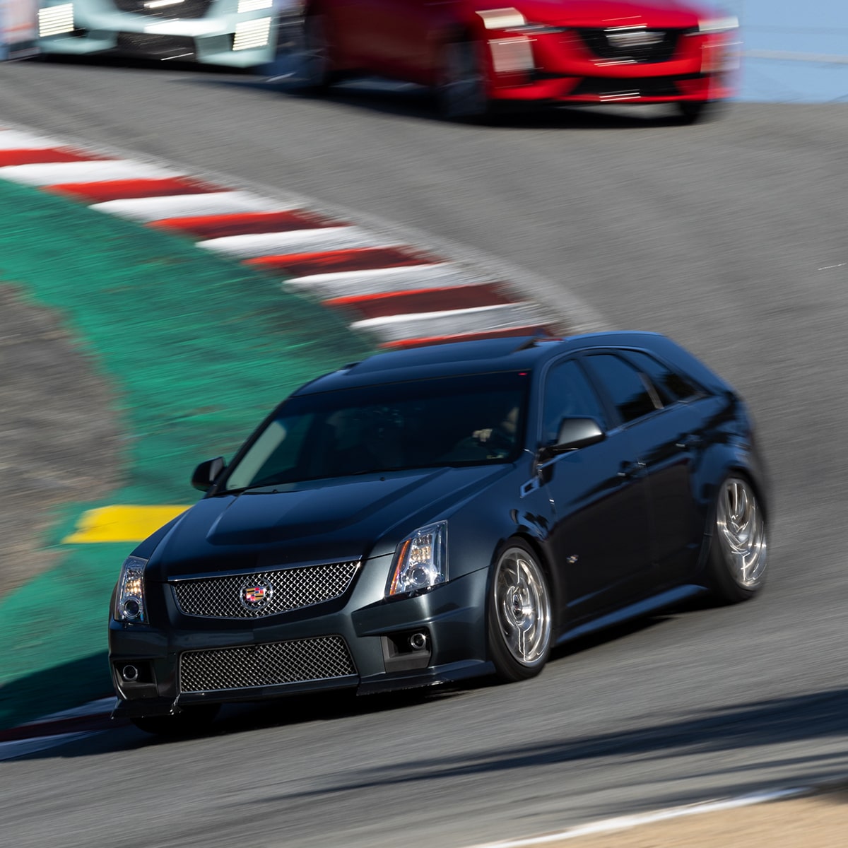 Cadillac CTS-V en Negro corriendo en una pista de carreras, seguido por otros vehículos