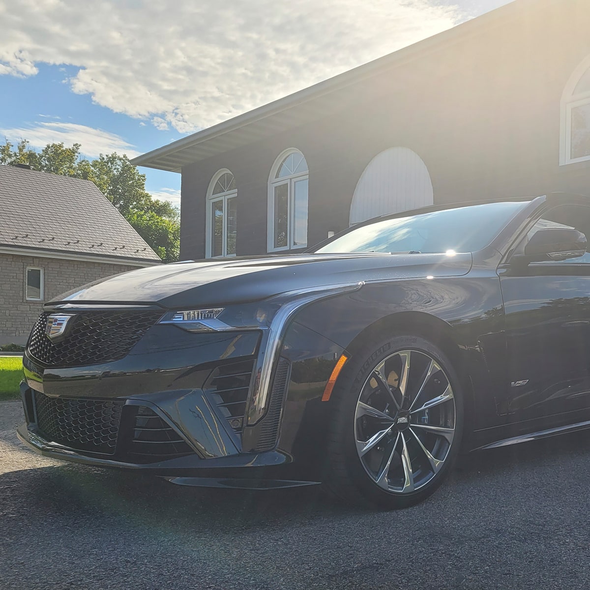 Sol brillando en un Cadillac V-Series Blackwing estacionado en una entrada de garaje