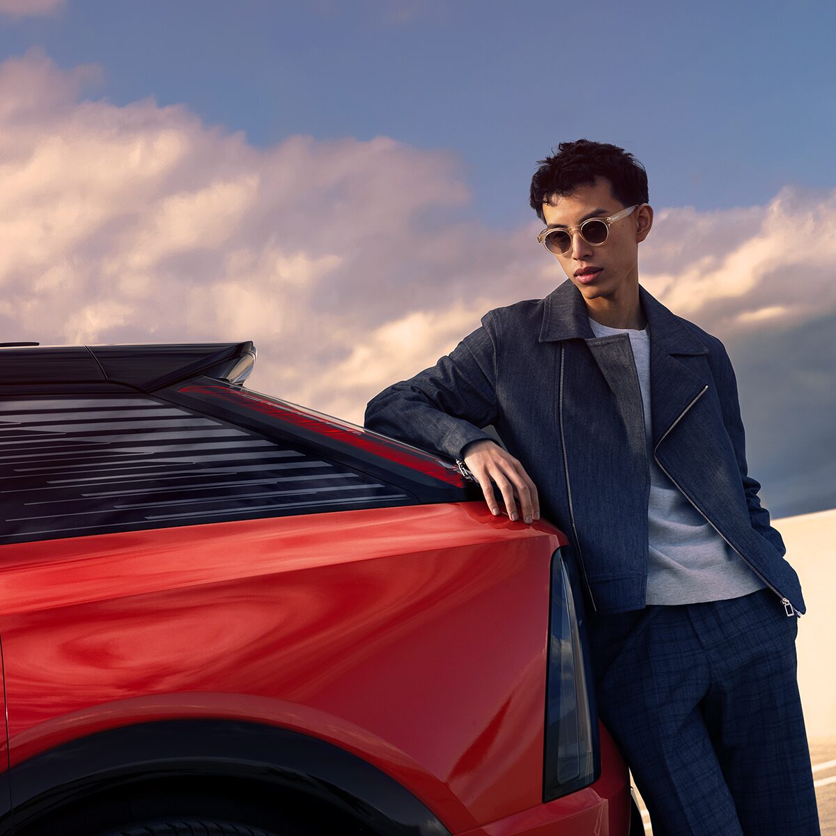 A Model Posing Inside the Driver's Seat of a Cadillac on a Sunny Day