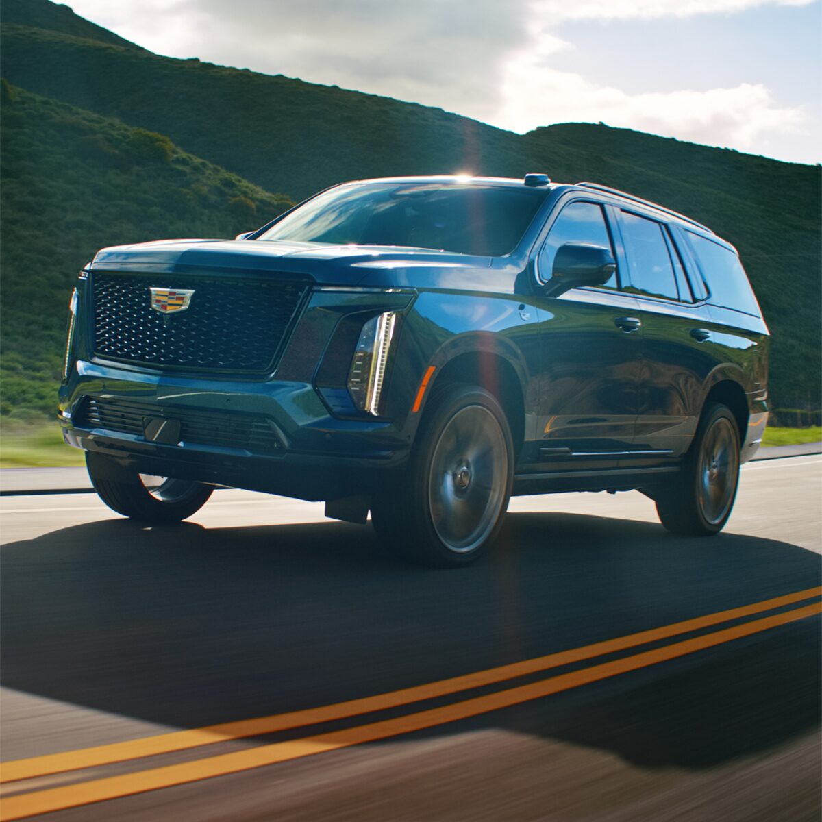 Front View of a Red Cadillac Escalade Parked By the Mountains