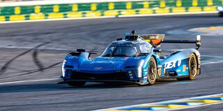 Front View of the Red V-Series.R Racecar Speeding Down on a Track