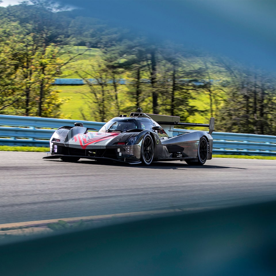 Cadillac Racing lmdh-V Race Car Zooming on Bend of the Race Track