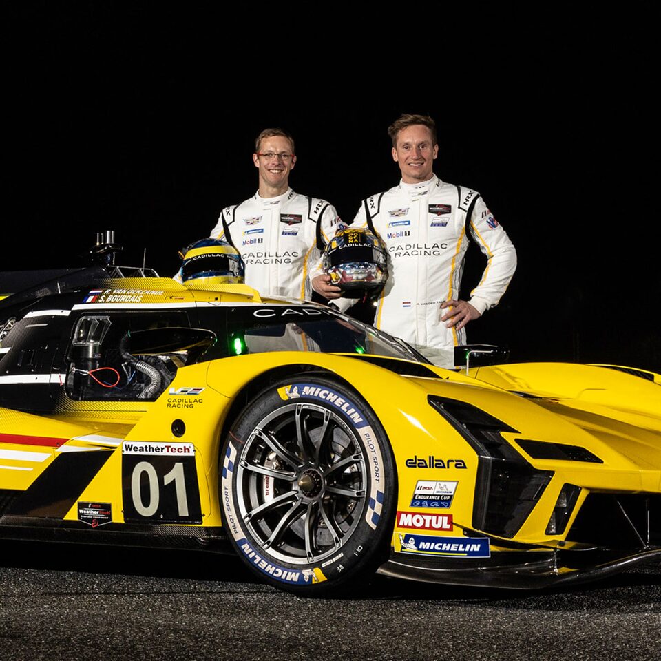 Two Cadillac Drivers Stand Besides the V-Series.R Electrified Race Car