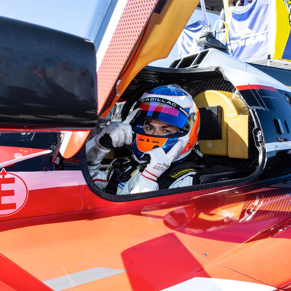 The Cadillac V-Series.R Driver Sitting in a Cadillac Racing Vehicle While Raising Their Visor
