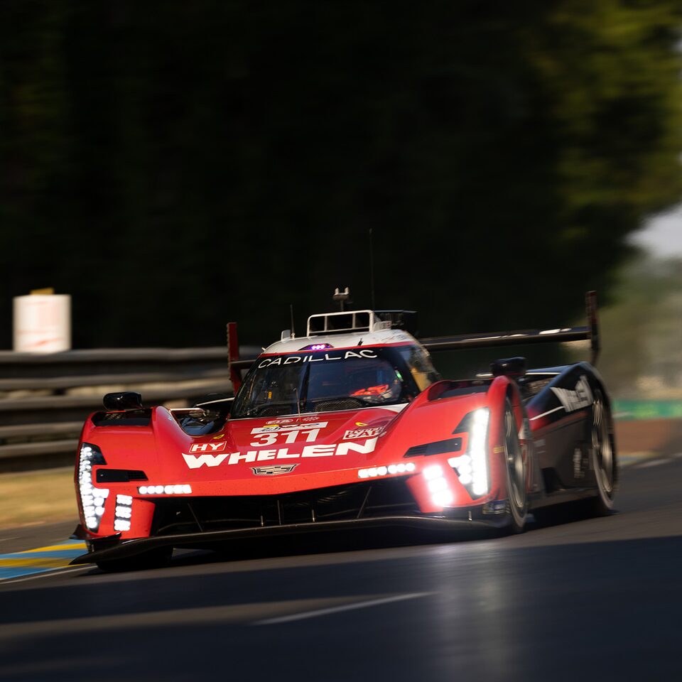 Front End View Of Red Cadillac V-Series.R Race Car With Head Lights On