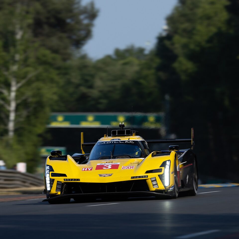 Front End View Of Yellow Cadillac V-Series.R Race Car Slowing Down On Track