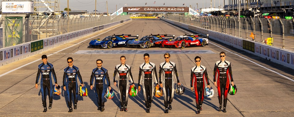 Cadillac Racing Team Members Lined Up Walking Away From Parked Race Cars on the Track