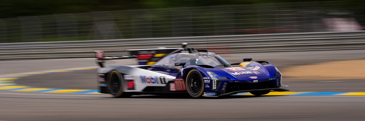 Three-Quarters View of the Blue Cadillac V-Series.R Race Car Speeding Around the Curve of a Track