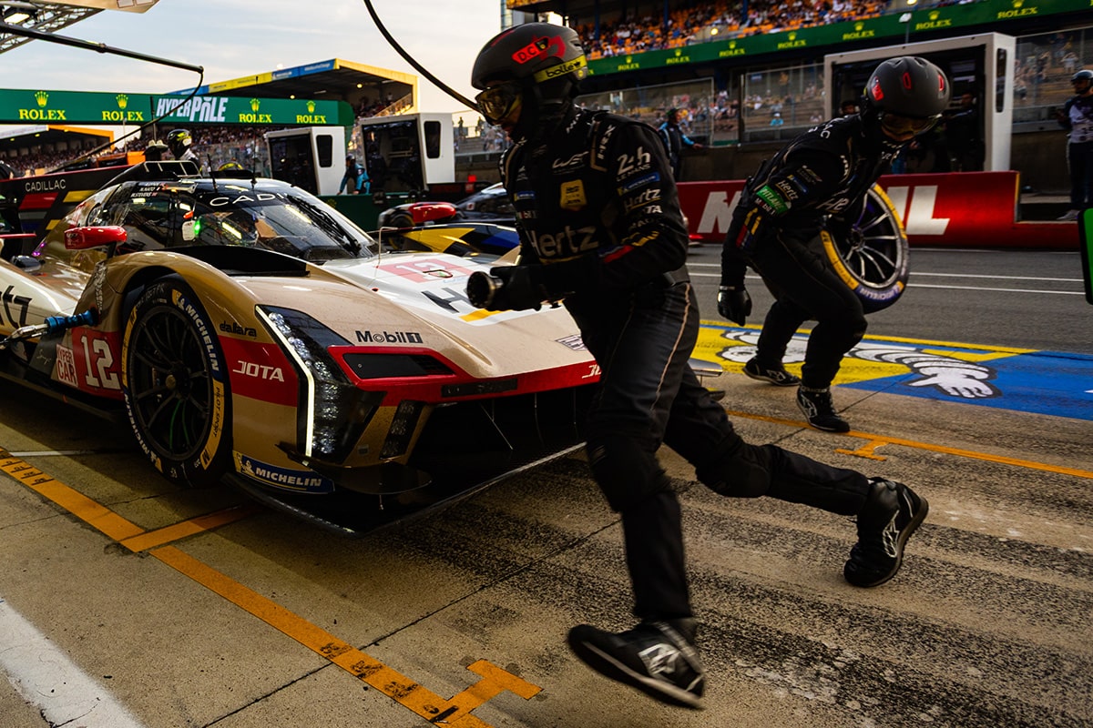 A Cadillac V-Series.R Race Car Parked in the Pit Stop While the Team Rushes to Change Tires