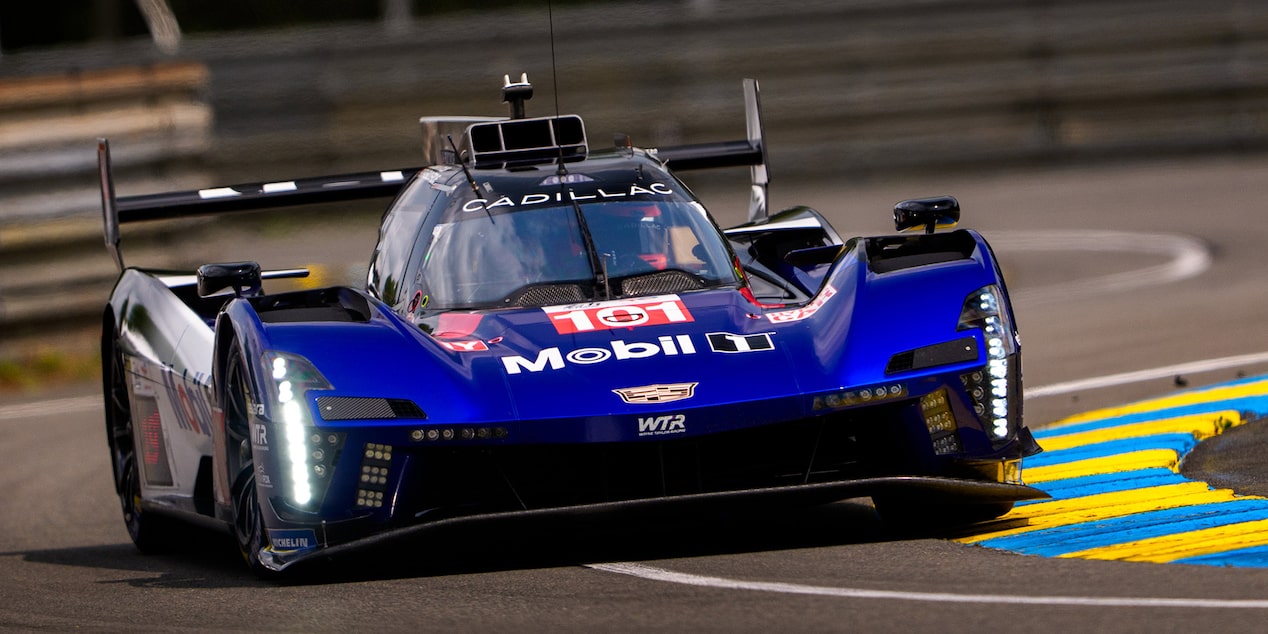 Front View of the Blue Cadillac V-Series.R Race Car Driving Around the Curve of a Track