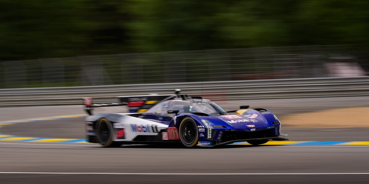Three-Quarters View of the Blue Cadillac V-Series.R Race Car Speeding Around the Curve of a Track