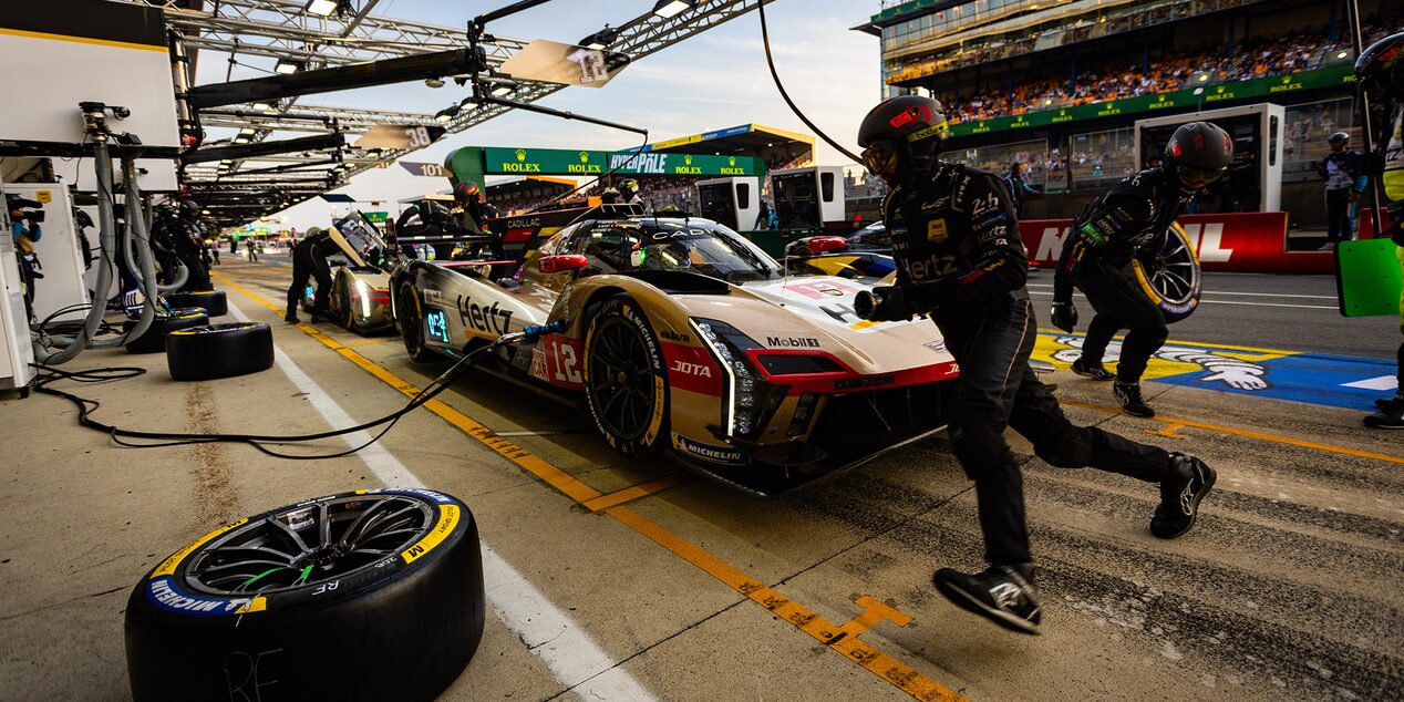 A Cadillac V-Series.R Race Car Parked in the Pit Stop While the Team Rushes to Change Tires