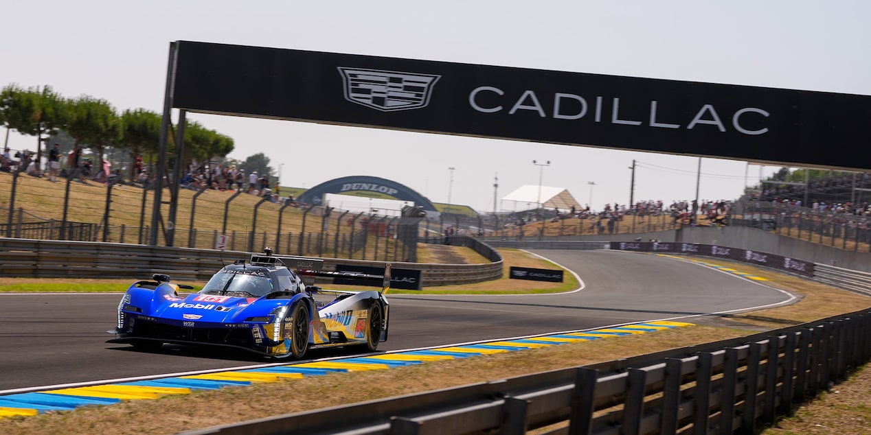 The Blue Cadillac V-Series.R Race Car Driving Under a Cadillac Banner on the Track