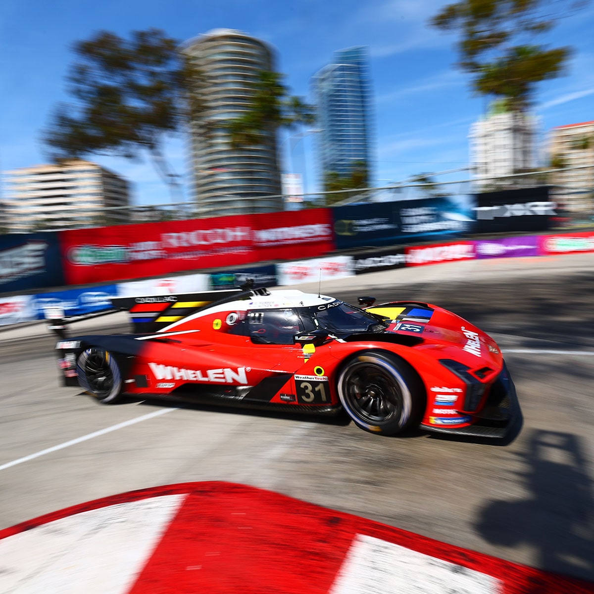 The Red Cadillac V-Series.R Race Car Speeding Around the Curve of the Race Track