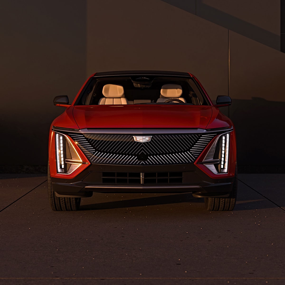 Two Cadillac LYRIQs Parked on the Drive of a Luxurious Home During Sunset
